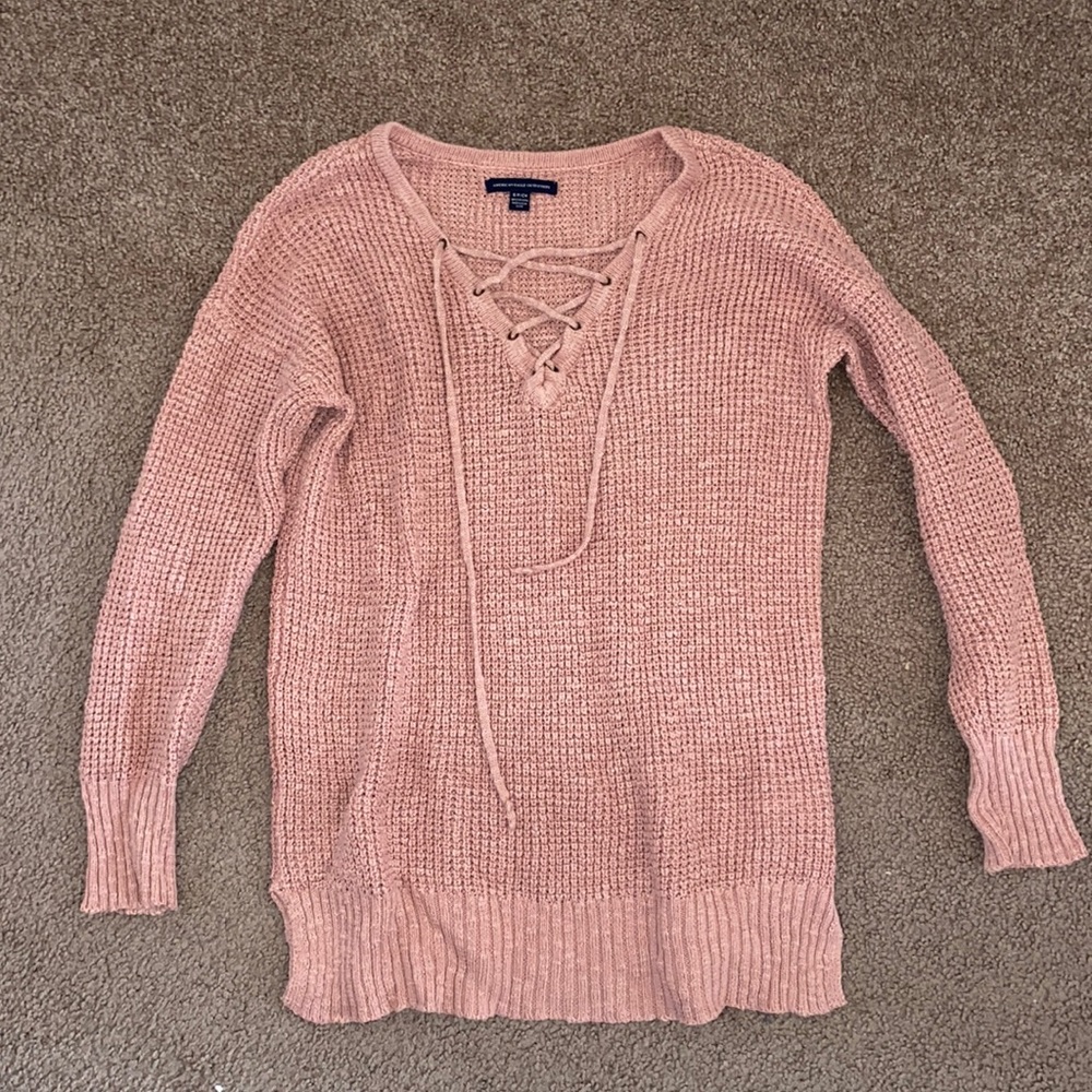 Soft pink sweater with crisscross neck design